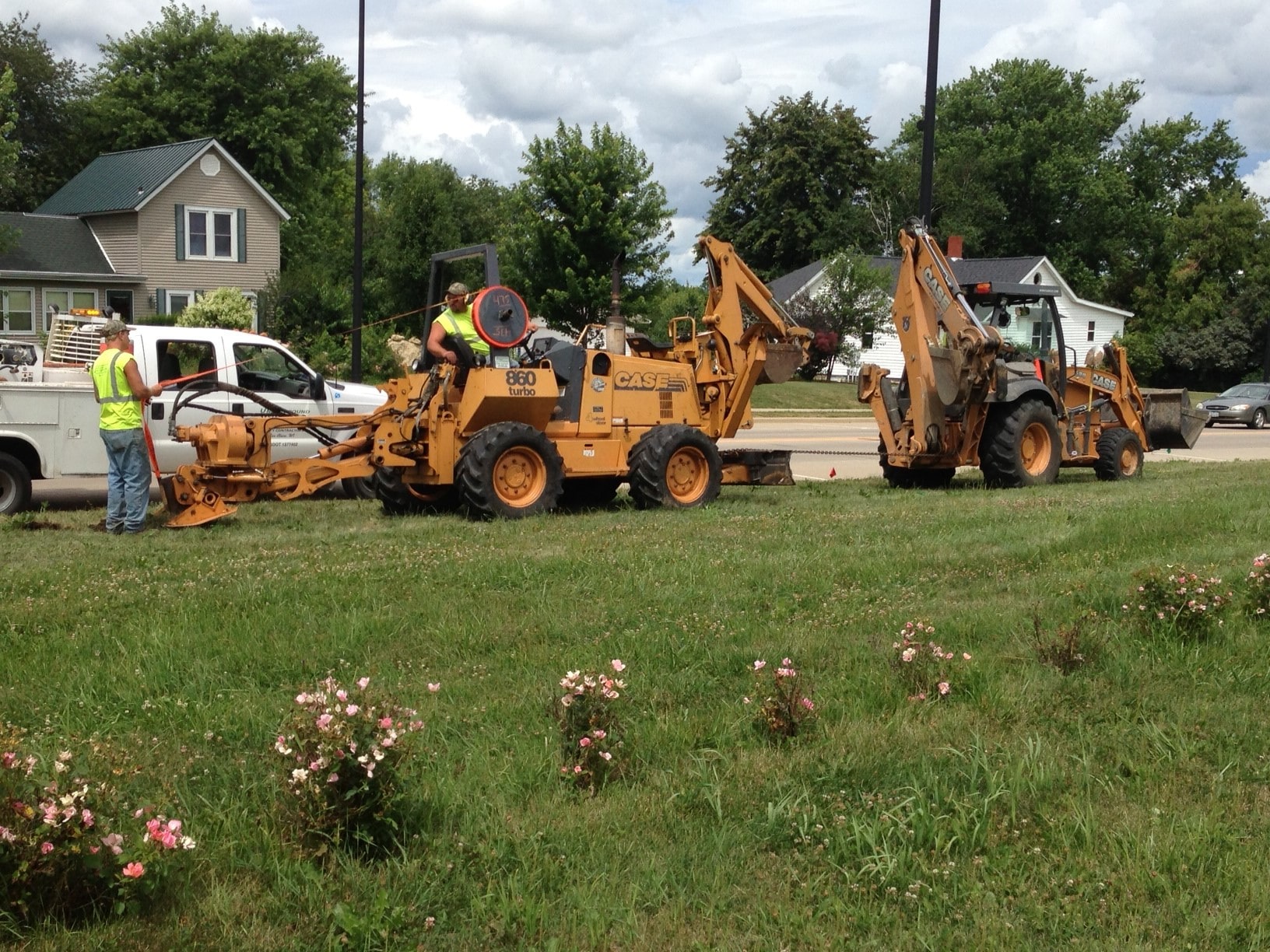 Backhoes laying fiber optic cable into the ground