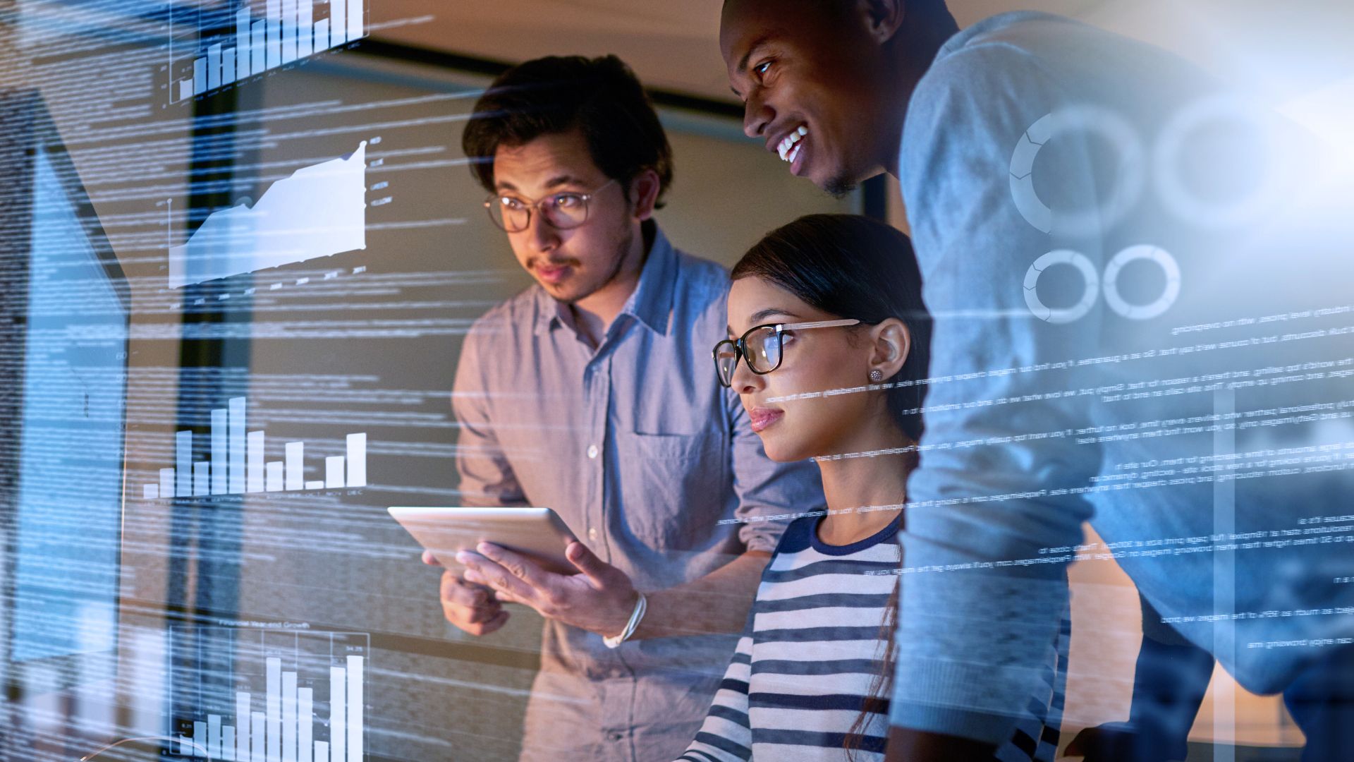 Three professionals collaborating around a tablet, with overlaid digital graphs and data charts